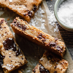 A slice of blondie on its side to expose the chewy, gooey texture.