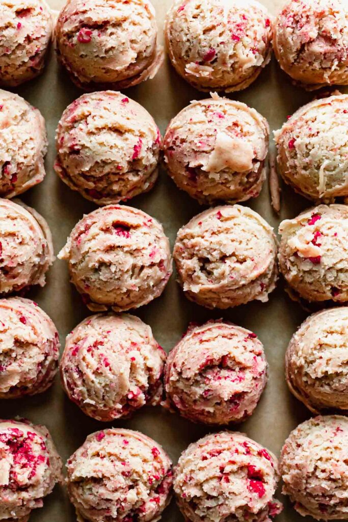 Closeup of cereal cookie dough balls on a baking sheet.