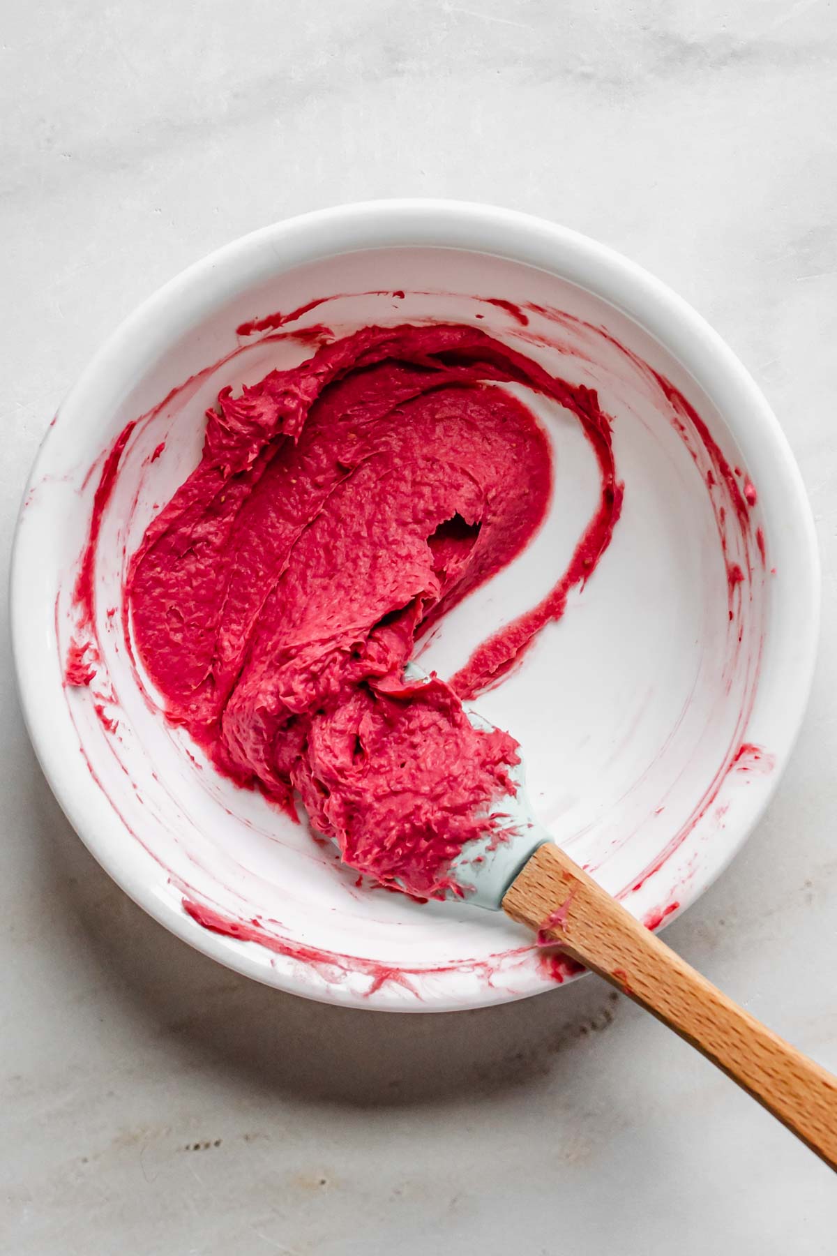 A hot pink paste is formed with freeze dried strawberry powder and heavy cream.