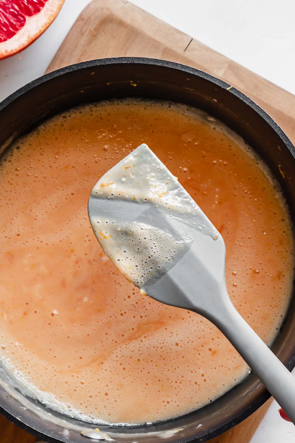 A spatula has a swipe of curd removed to show its thickness.