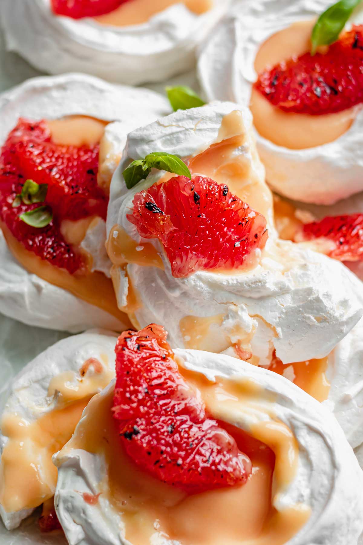A pile of mini pavlovas with one broken sitting on top.