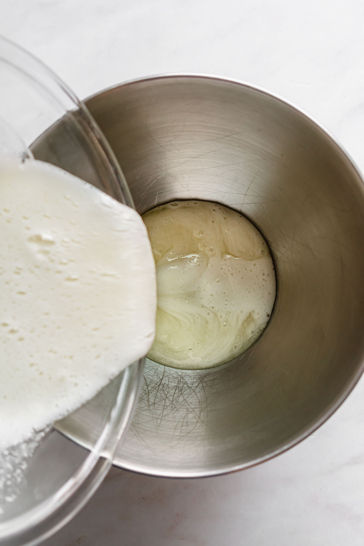 Heated eggs and sugar poured into the bowl of a stand mixer.