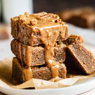 Stack of biscoff blondies with melted cookie butter drizzling over the edge.