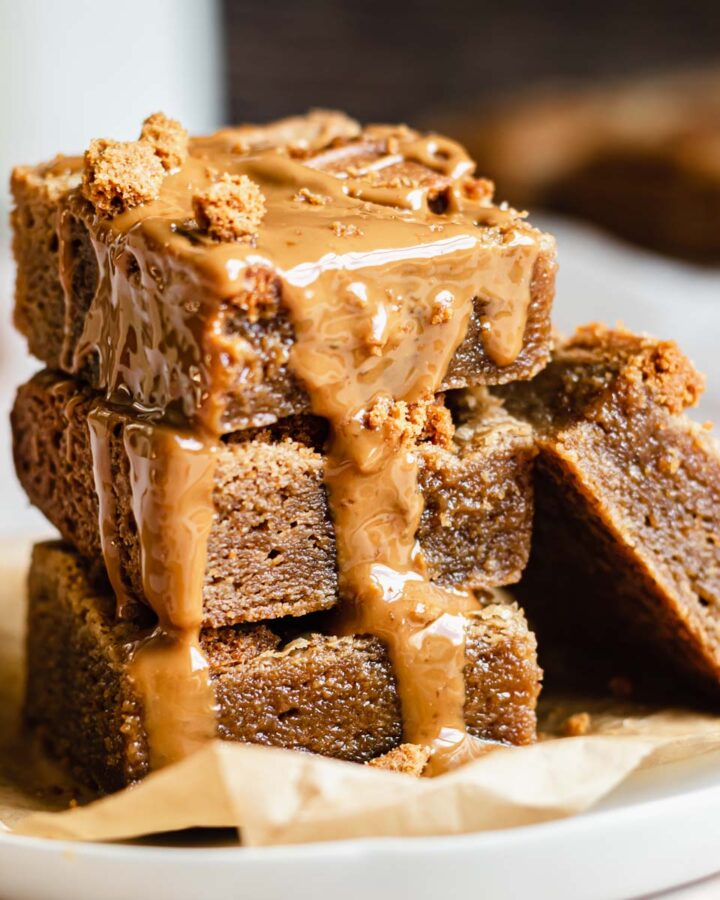 Stack of biscoff blondies with melted cookie butter drizzling over the edge.