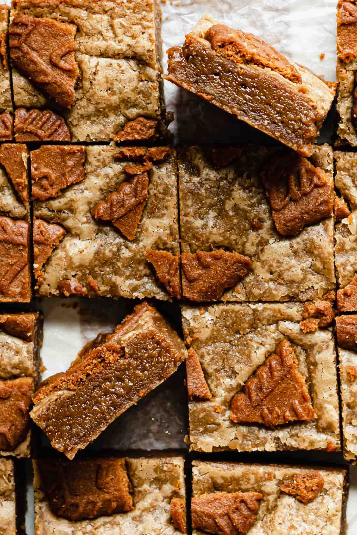 Overhead shot of cut biscoff blondies. Two lay on their edges to expose the fudgy centers