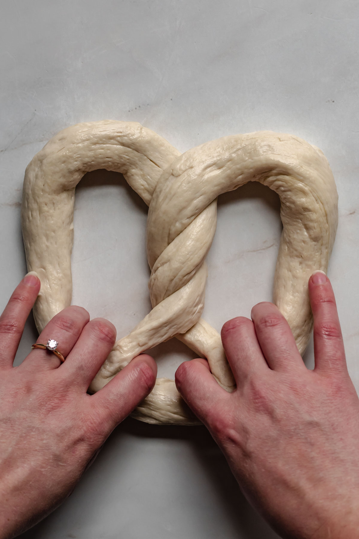 Soft pretzel dough being picked up.