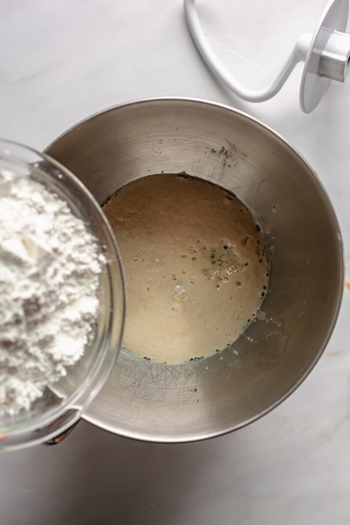 Flour being added to bloomed yeast.