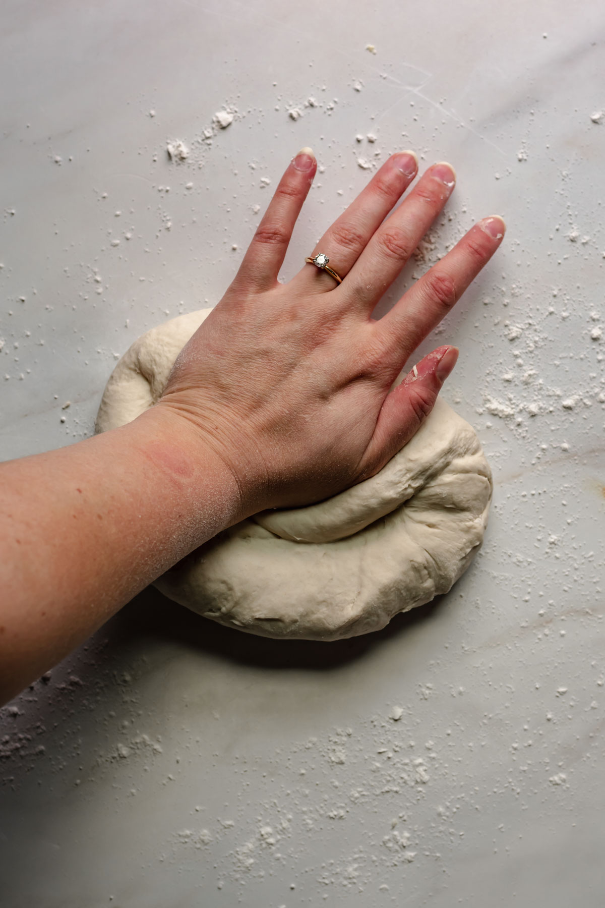 A hand kneading dough.