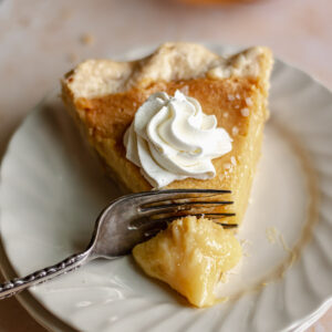 Slice of honey chess pie with a fork removing a slice.