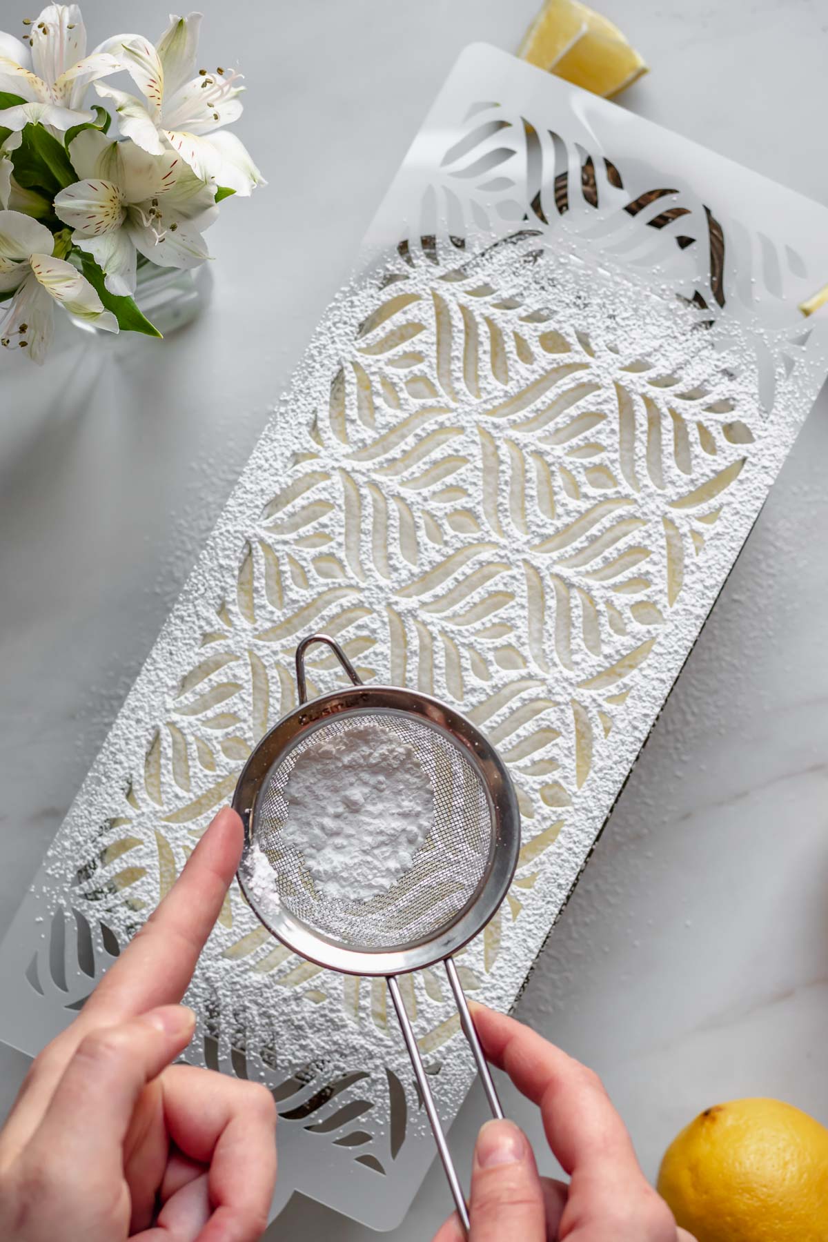 Powdered sugar being dusted on a stencil.