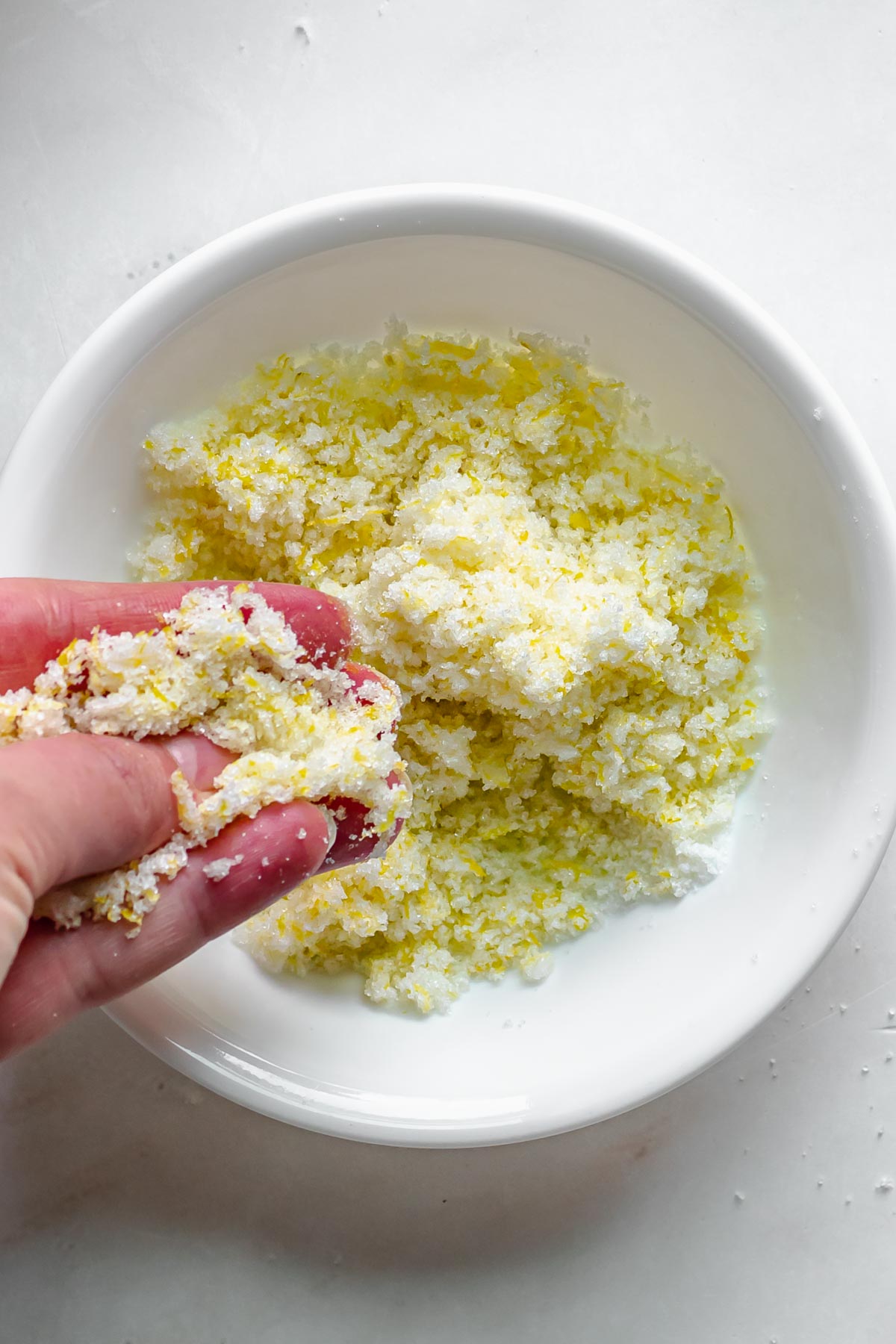 Lemon zest and sugar being rubbed together.