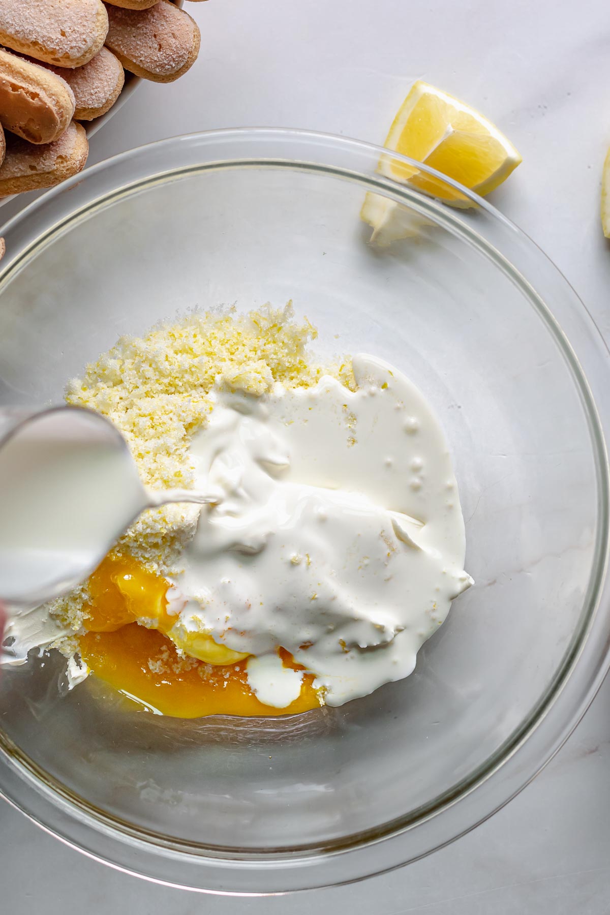 Heavy cream being added to all lemon cream ingredients.