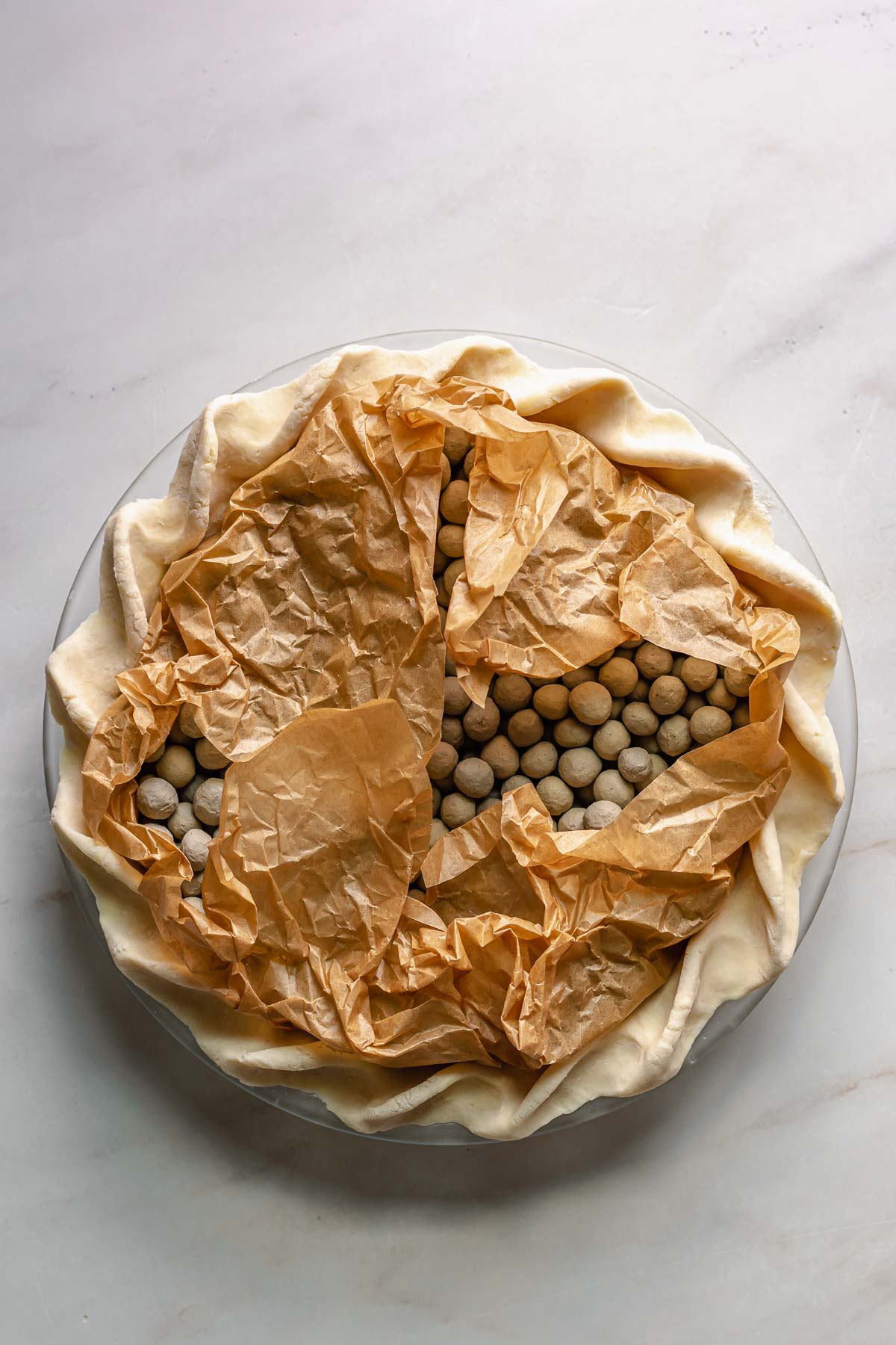Pie crust with parchment and pie weights.