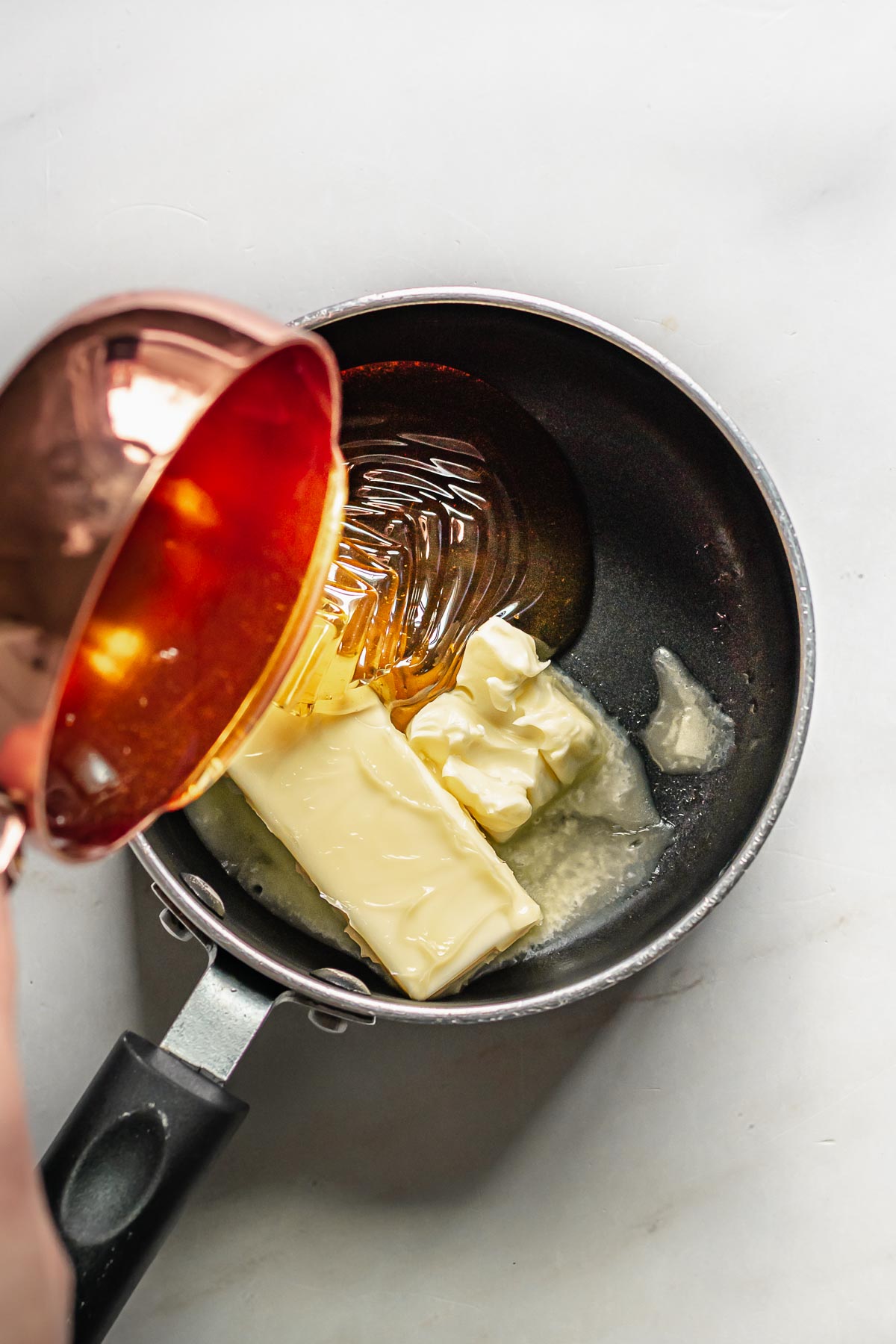 Honey being poured into a saucepan.