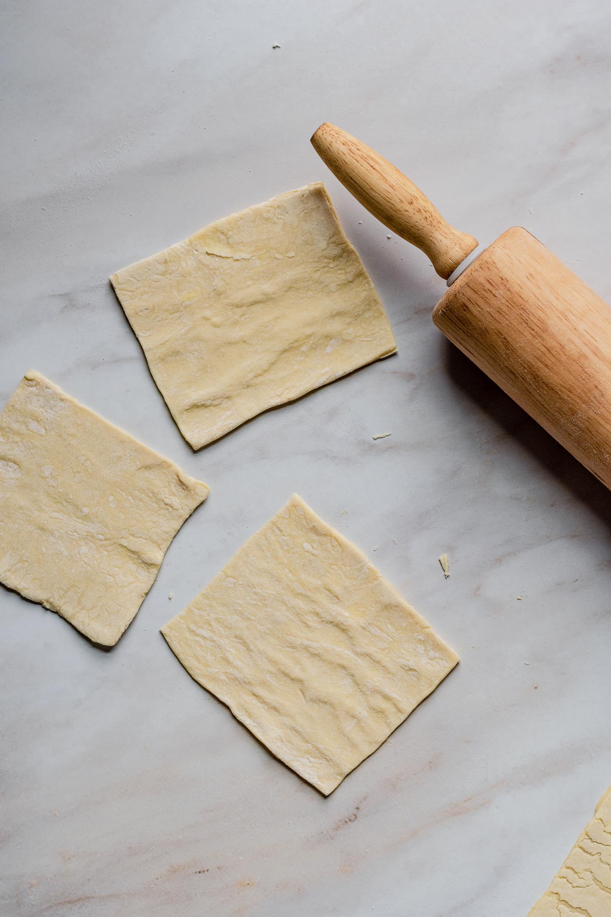 Squares of puff pastry and a rolling pin.