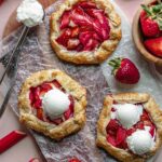 Three strawberry rhubarb tartlets with ice cream on two.