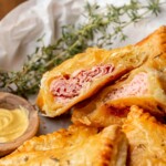 Ham and cheese puff pastry cut open to expose the center.