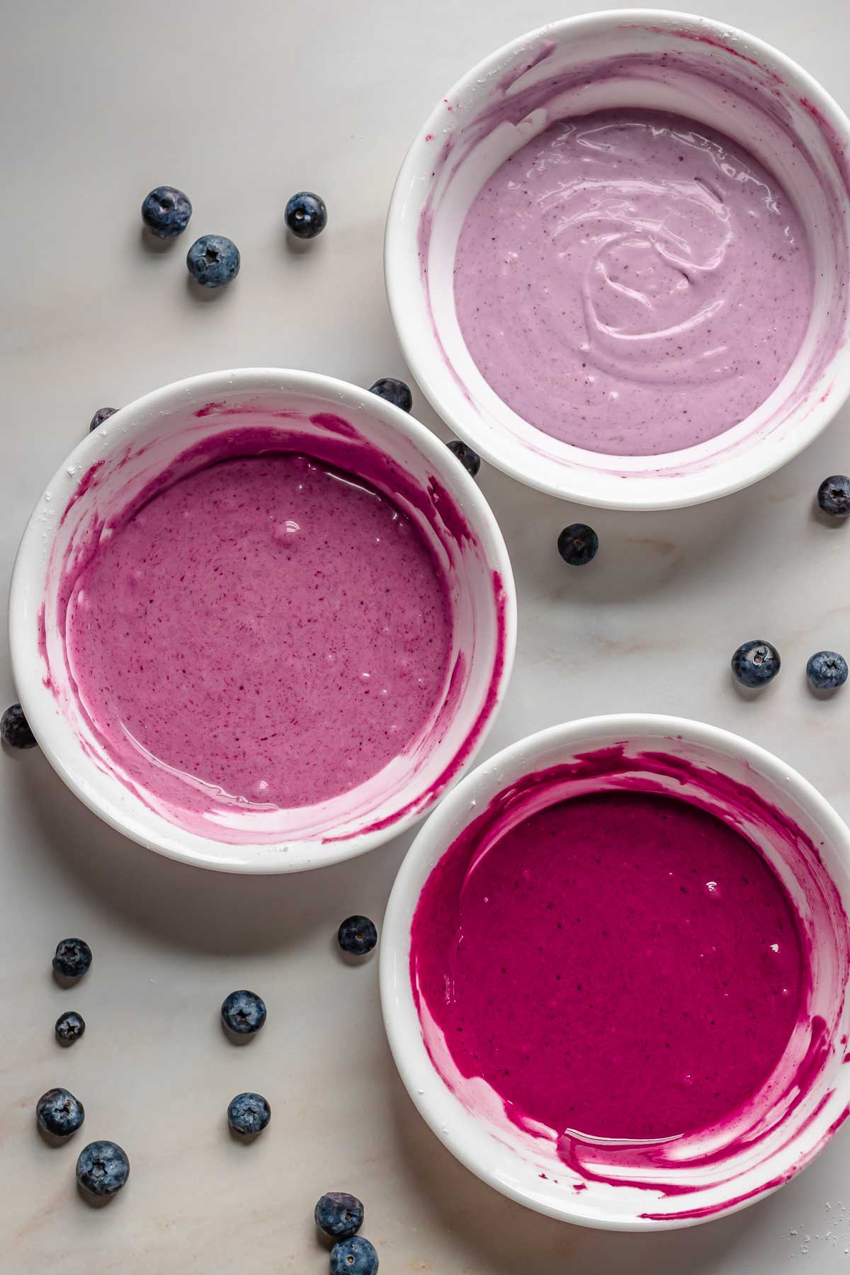 Bowls with three different colors of blueberry glaze.