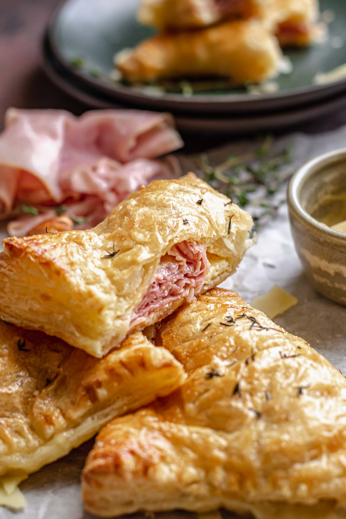Ham and cheese turnovers on a table. One is cut open.