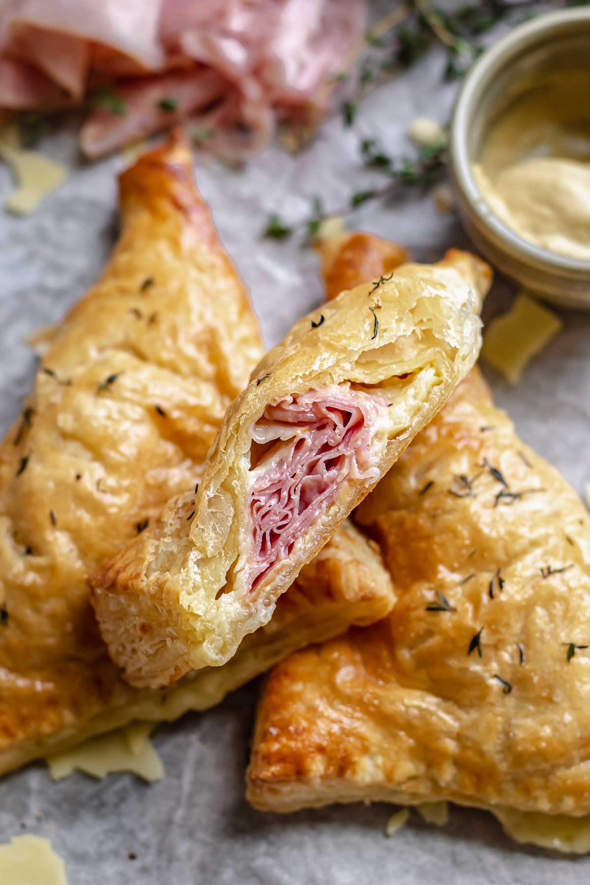 Ham and cheese turnovers with a bite removed to show the cross section.