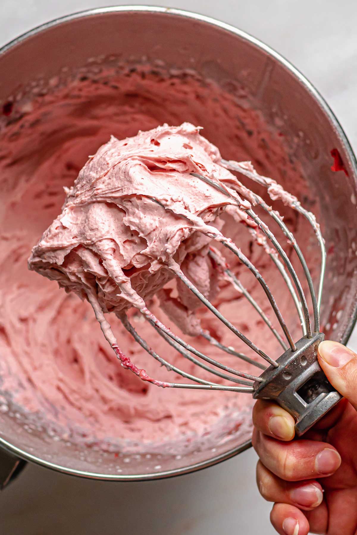 Freeze dried strawberry frosting on a whisk.