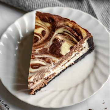 Slice of chocolate marble cheesecake on a plate.