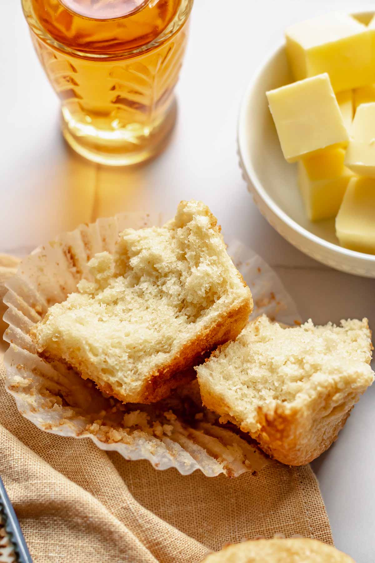 An open muffin with butter and rum next to it.