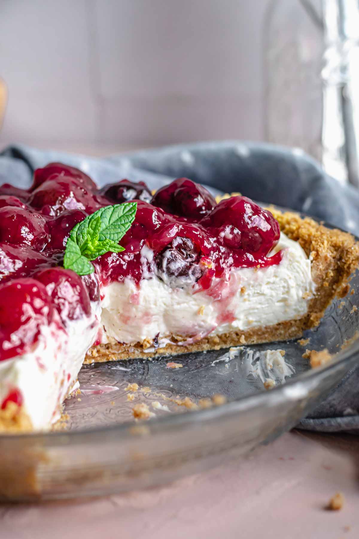 Cherry cheesecake pie in a pie plate with a slices removed.