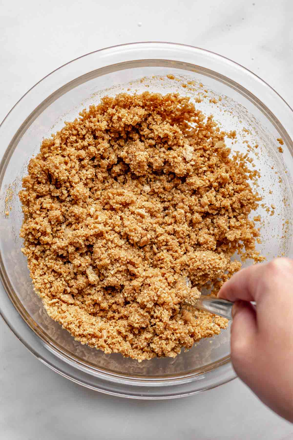 Mixing graham cracker crumbs together with a fork.