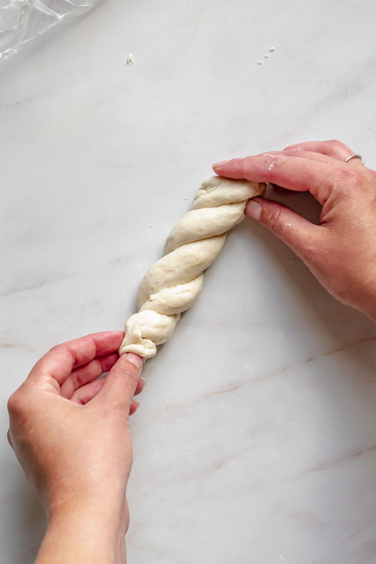 Twisting pretzel dough with two hands.