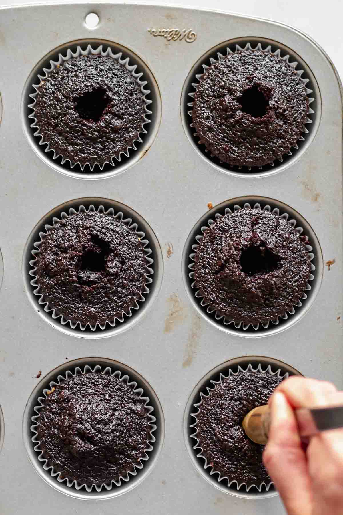 Coring chocolate cupcakes.