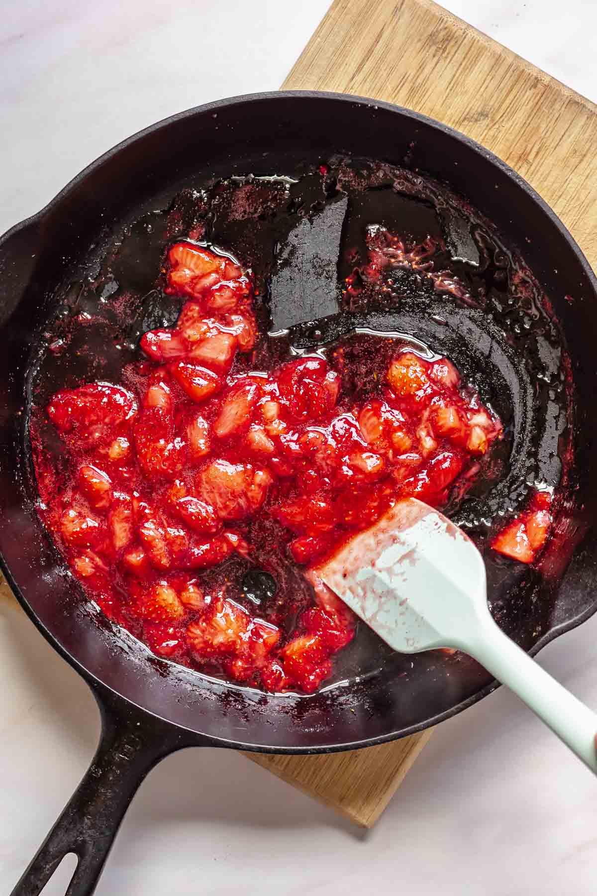 Strawberries cooking down in a pan.