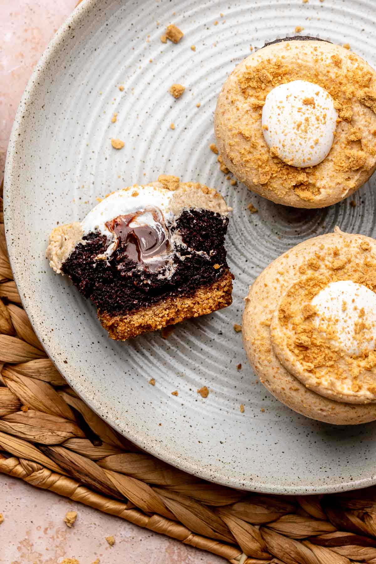 Graham cracker cupcakes on a plate. One is cut in half.