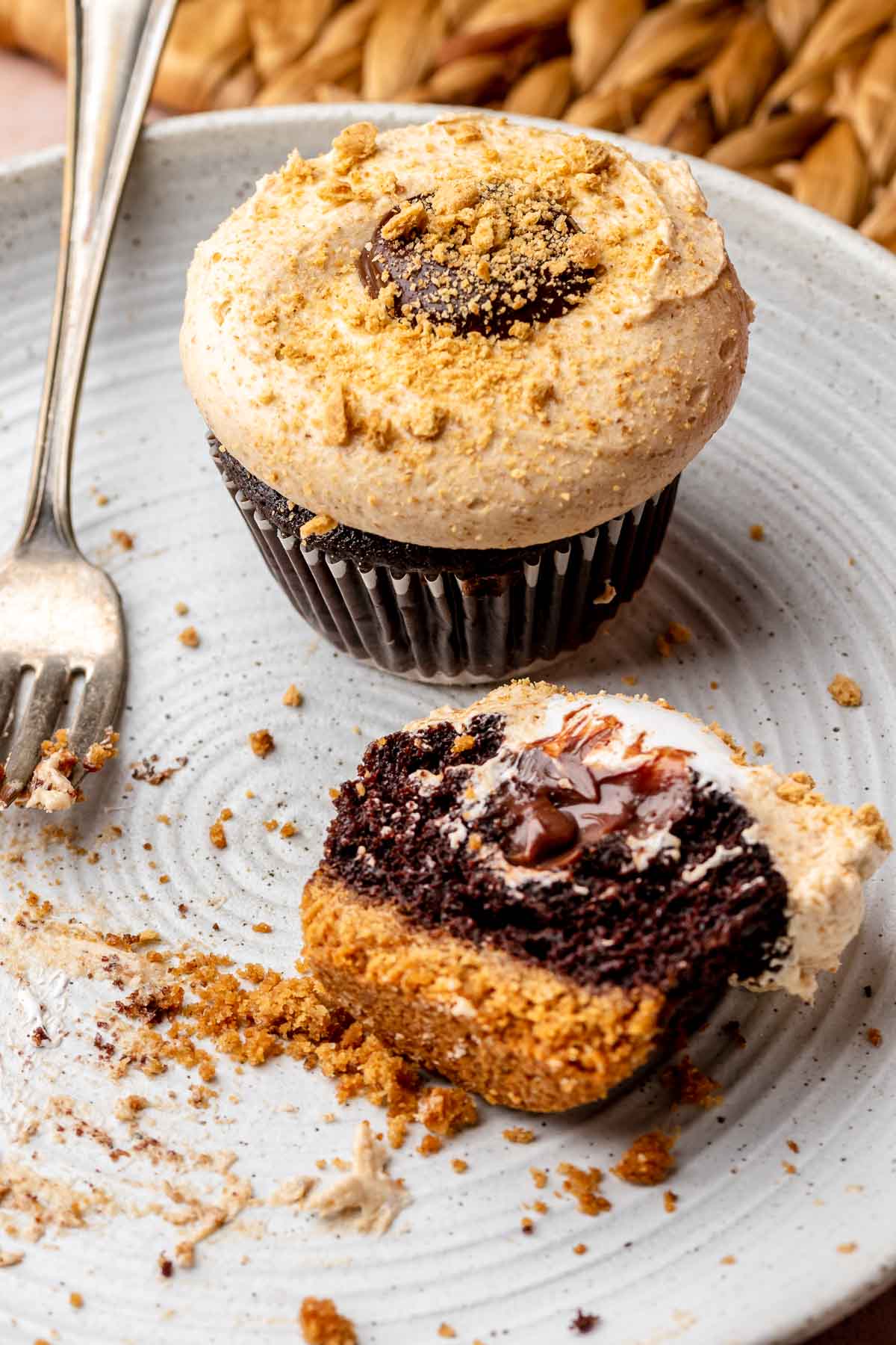 Graham cracker cupcakes on a plate. One is cut in half.