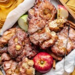 Basket of apple fritter donuts with apples nestled in.
