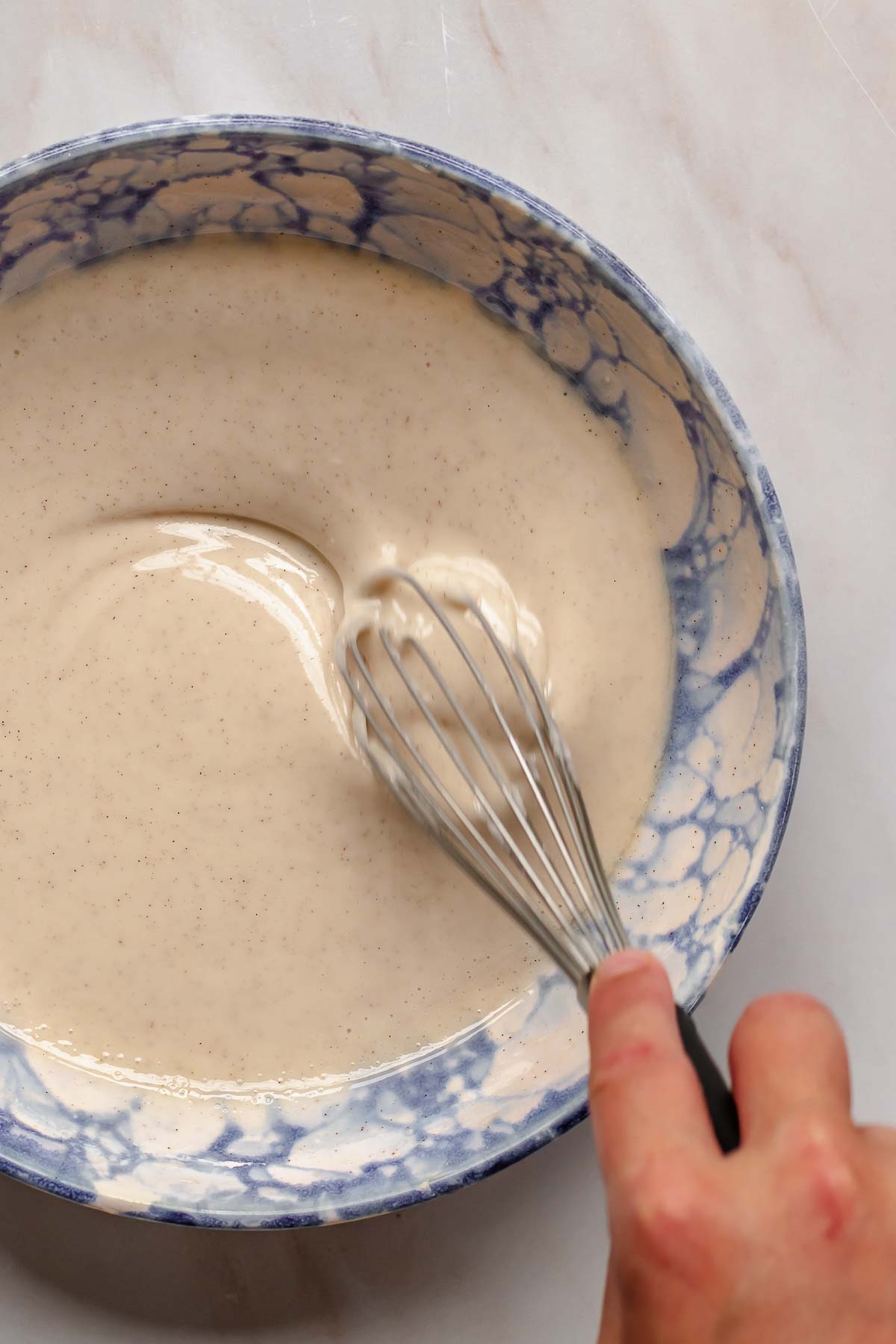 Whisking cinnamon glaze in a bowl.