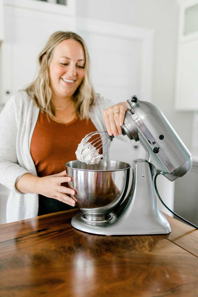 Removing a whisk of whipped cream from a stand mixer.