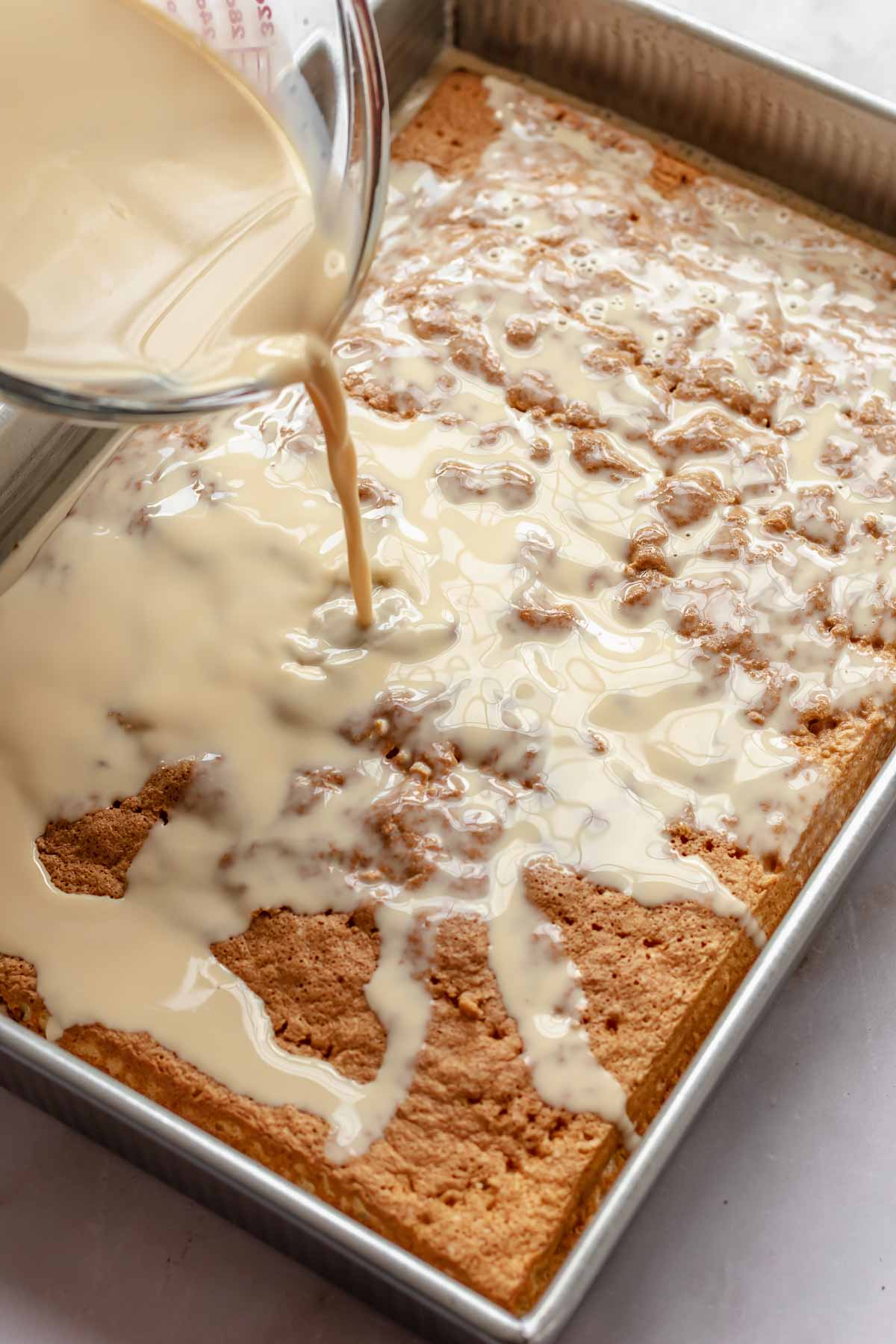 Caramel milk mixture pours on to the baked cake.