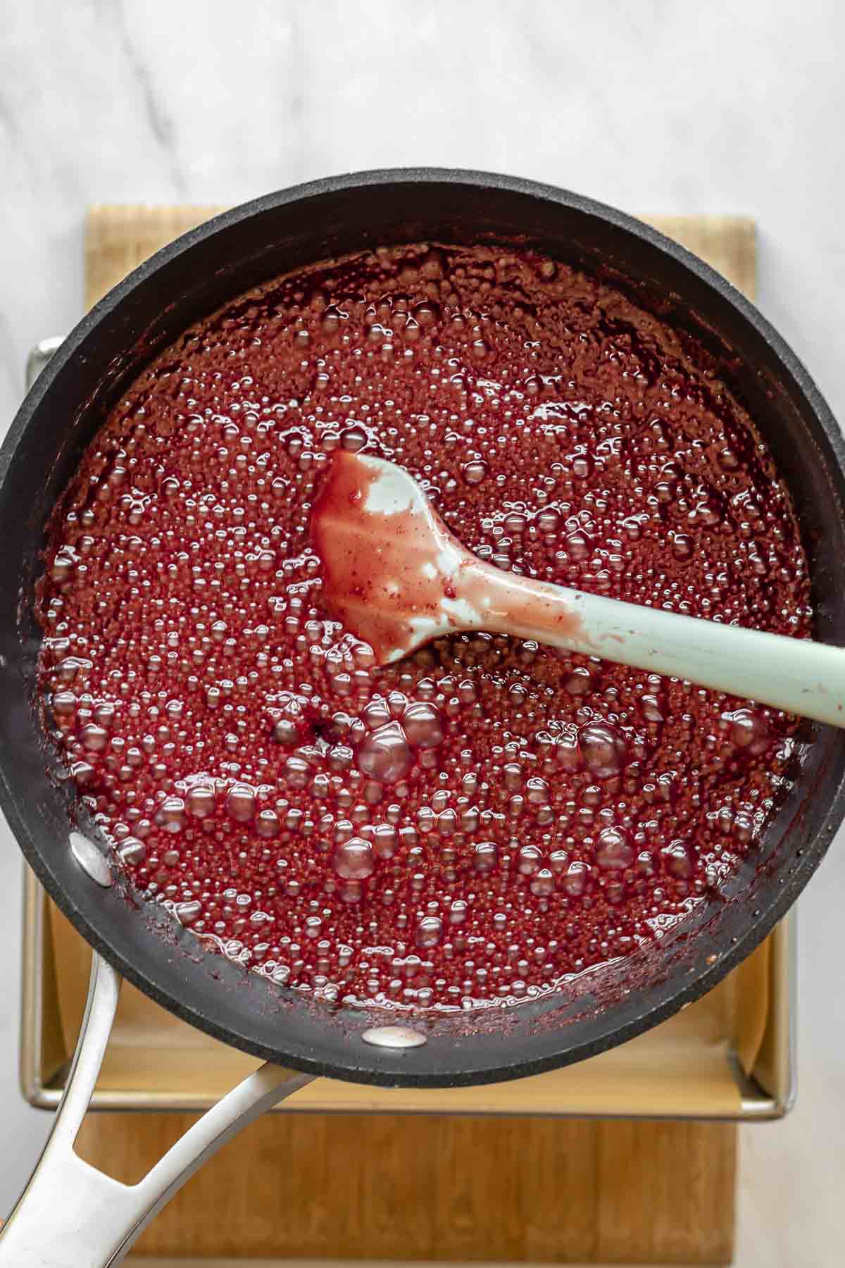 Bubbling pomegranate caramel in a pot.