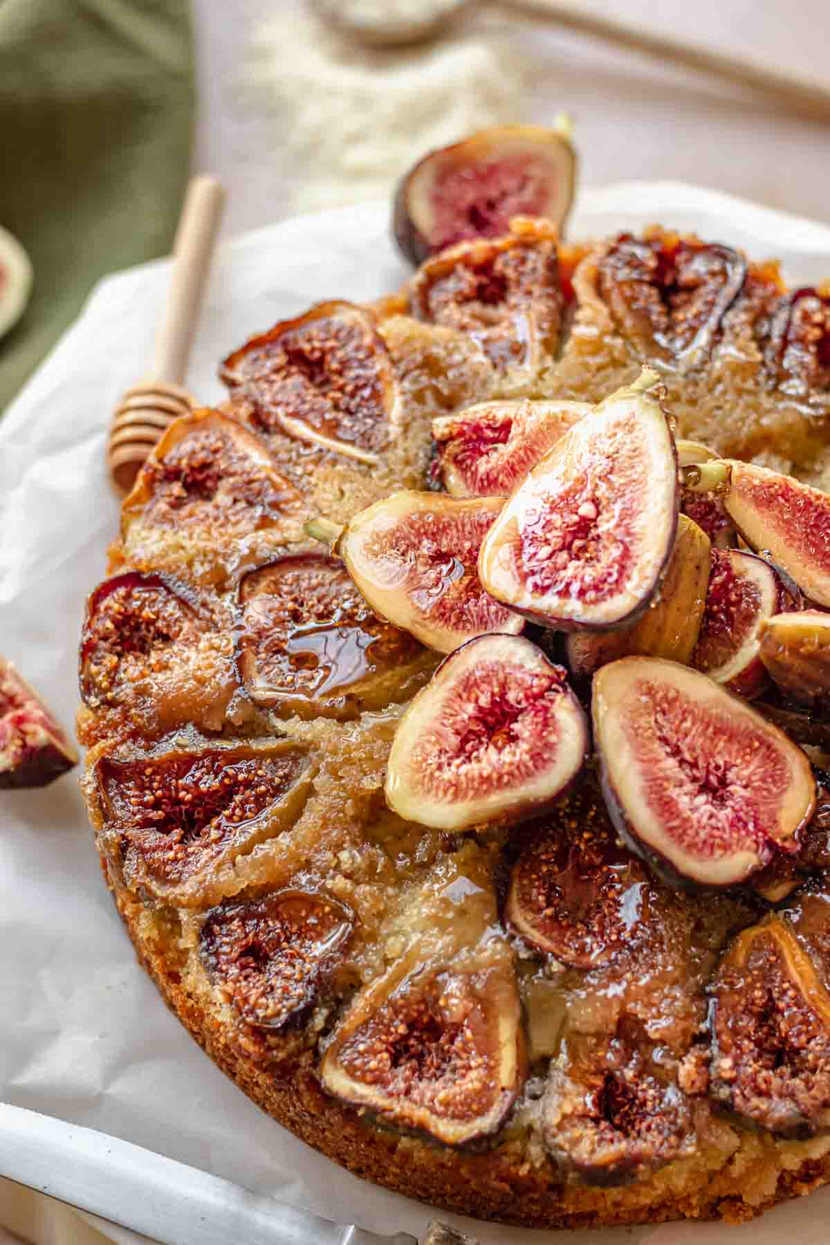 Fig cake on a platter with fresh figs and honey.