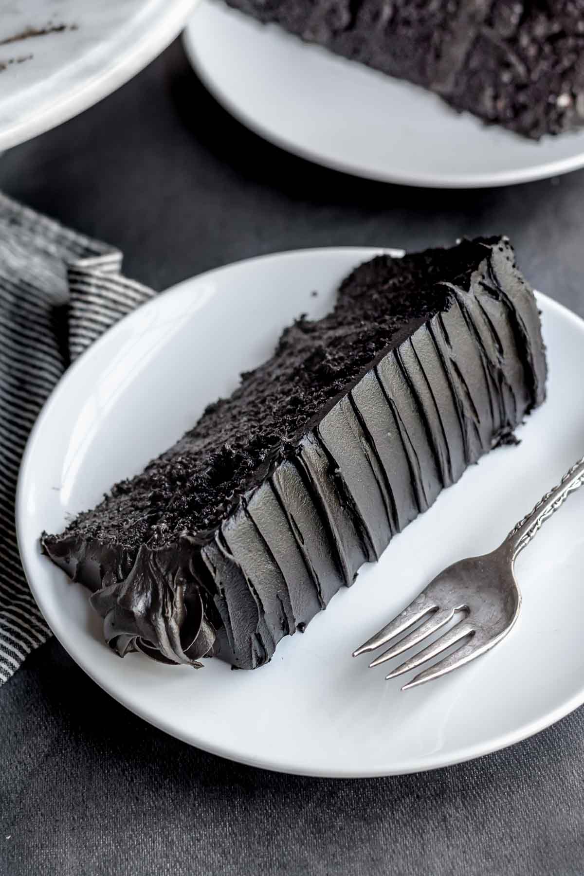 A slice of black velvet cake on a plate.