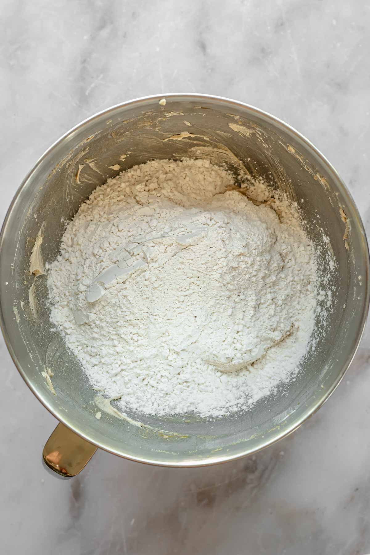 Flour on top of wet ingredients in a bowl.