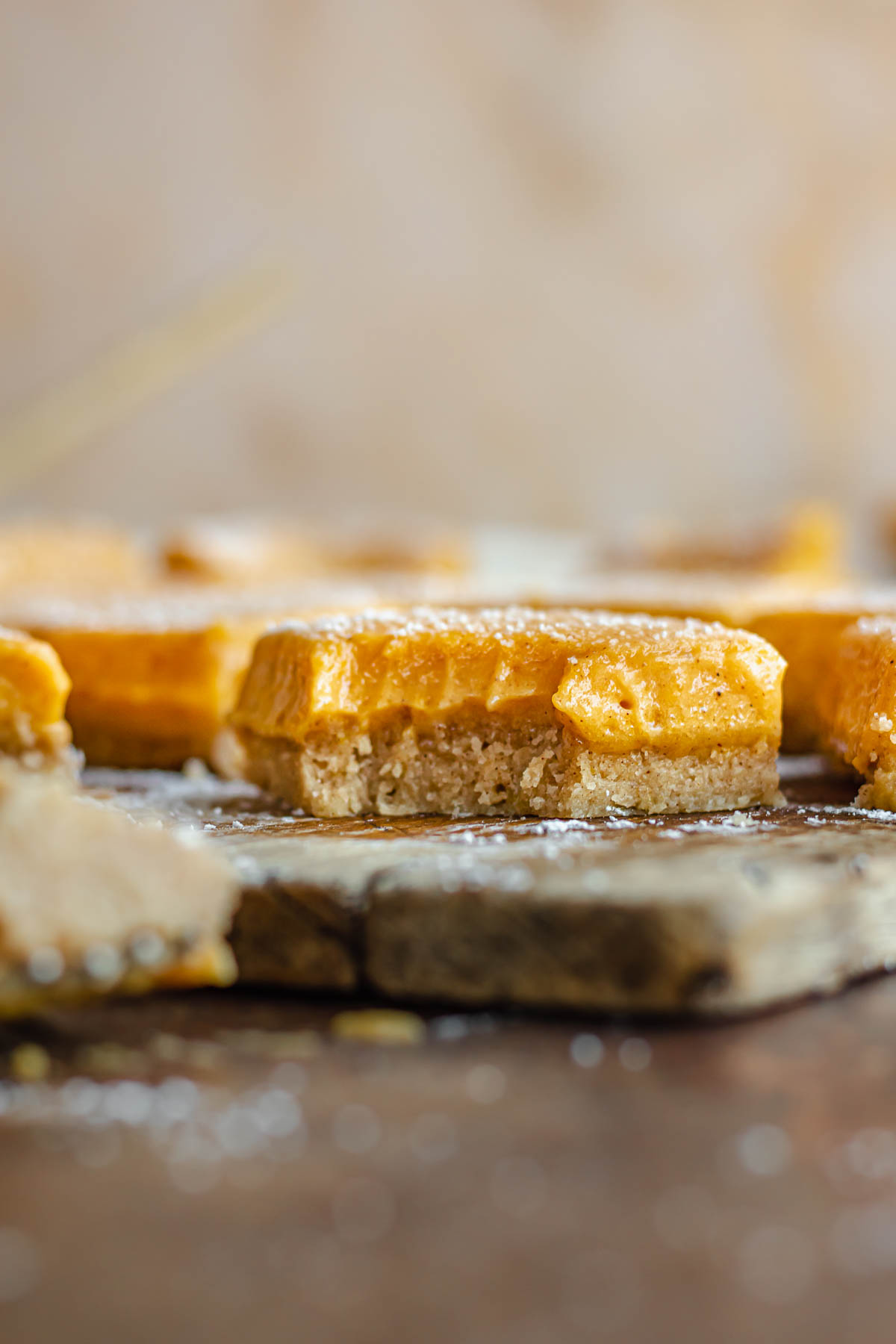 Pumpkin bars on a cutting board. One has a bite removed.