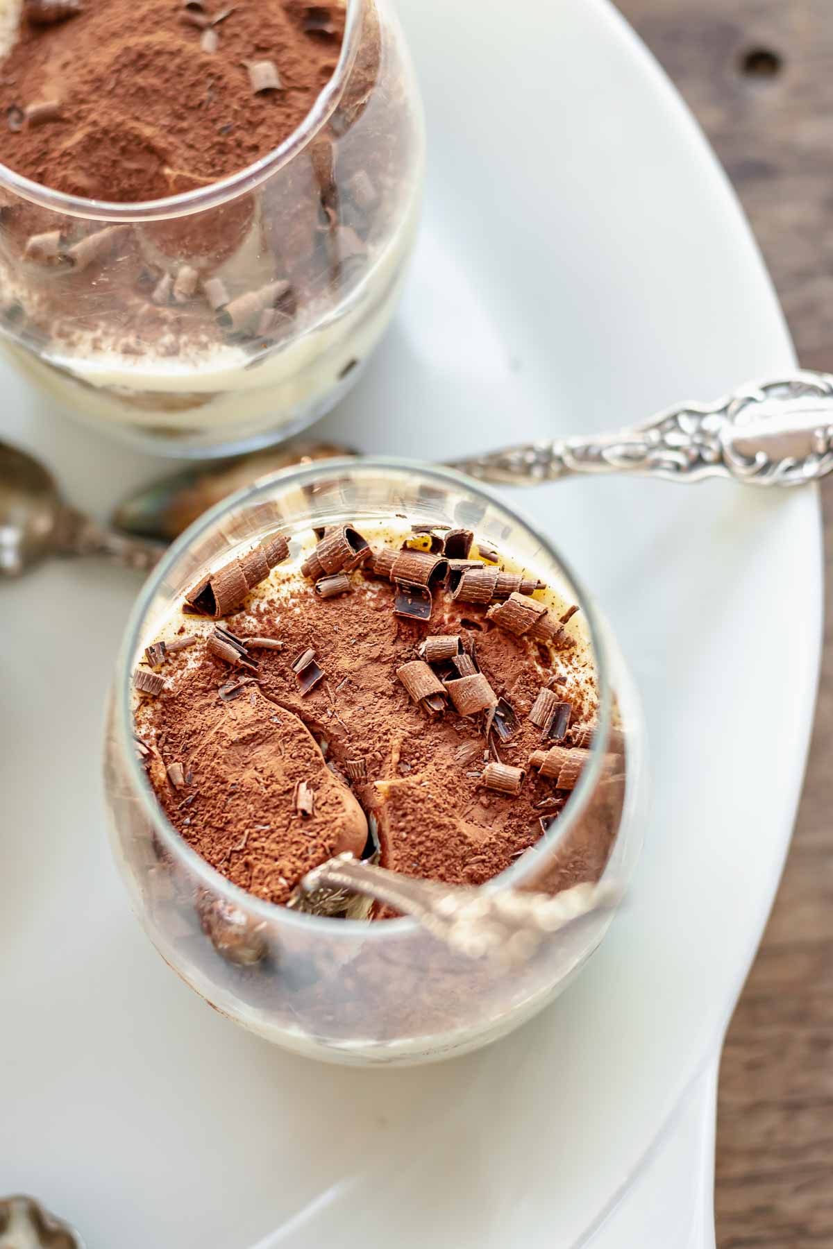 A tiramisu cup with a spoon in it.