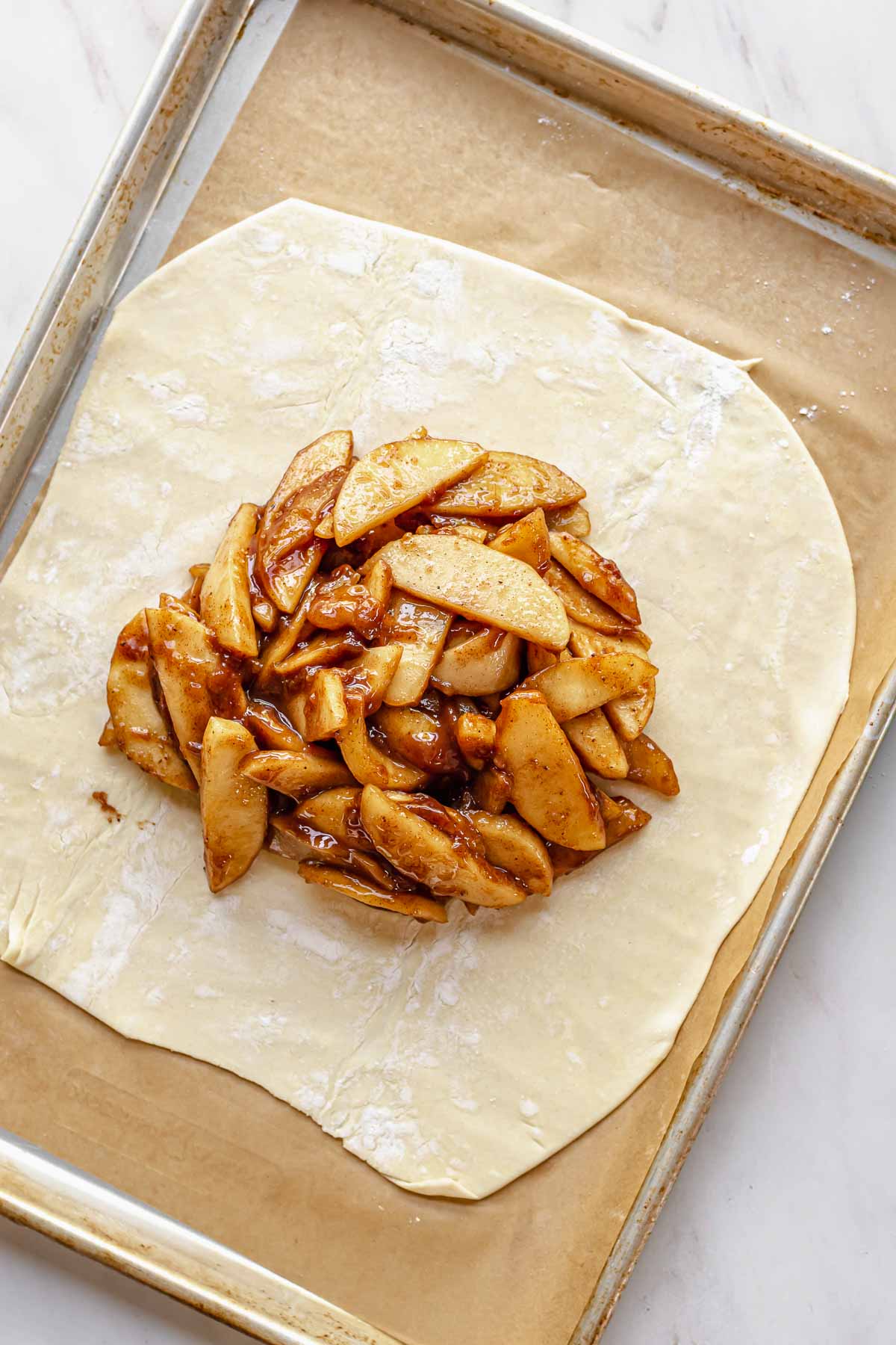 Apples mounded in the center of a piece of puff pastry.