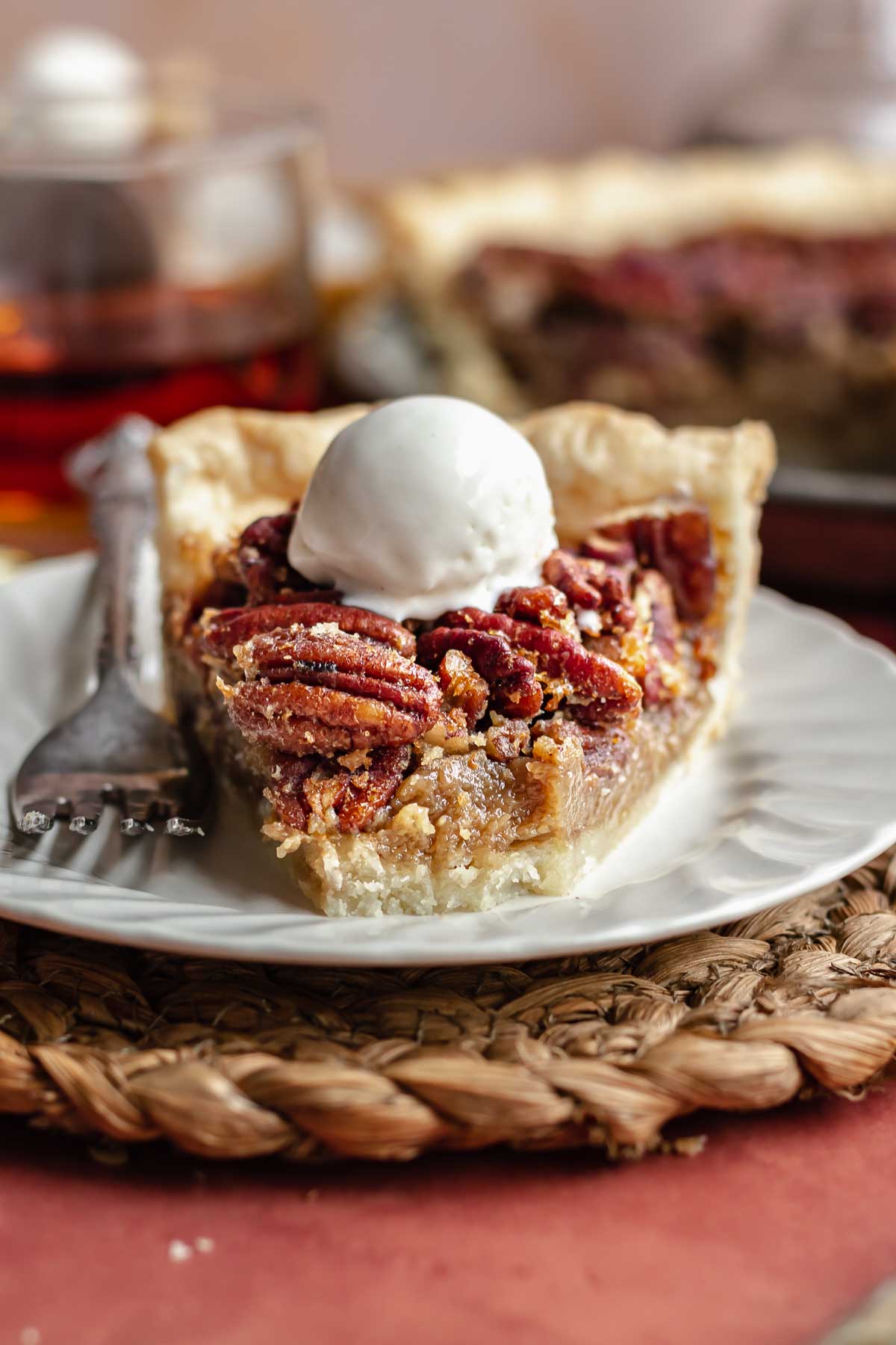A slice of pecan pie with ice cream on top. The front bite is removed.