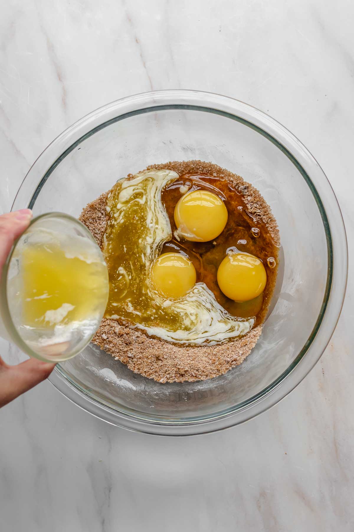 Eggs and butter being added to a mixing bowl.