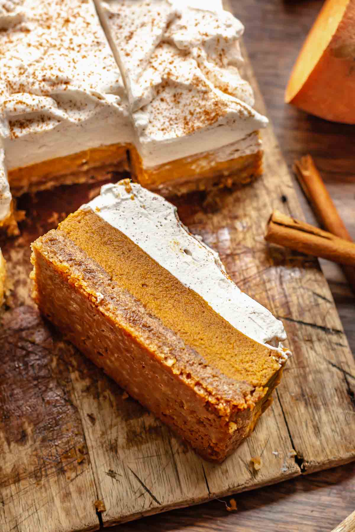 A slice of sweet potato pie bar lays on its side on a cutting board.