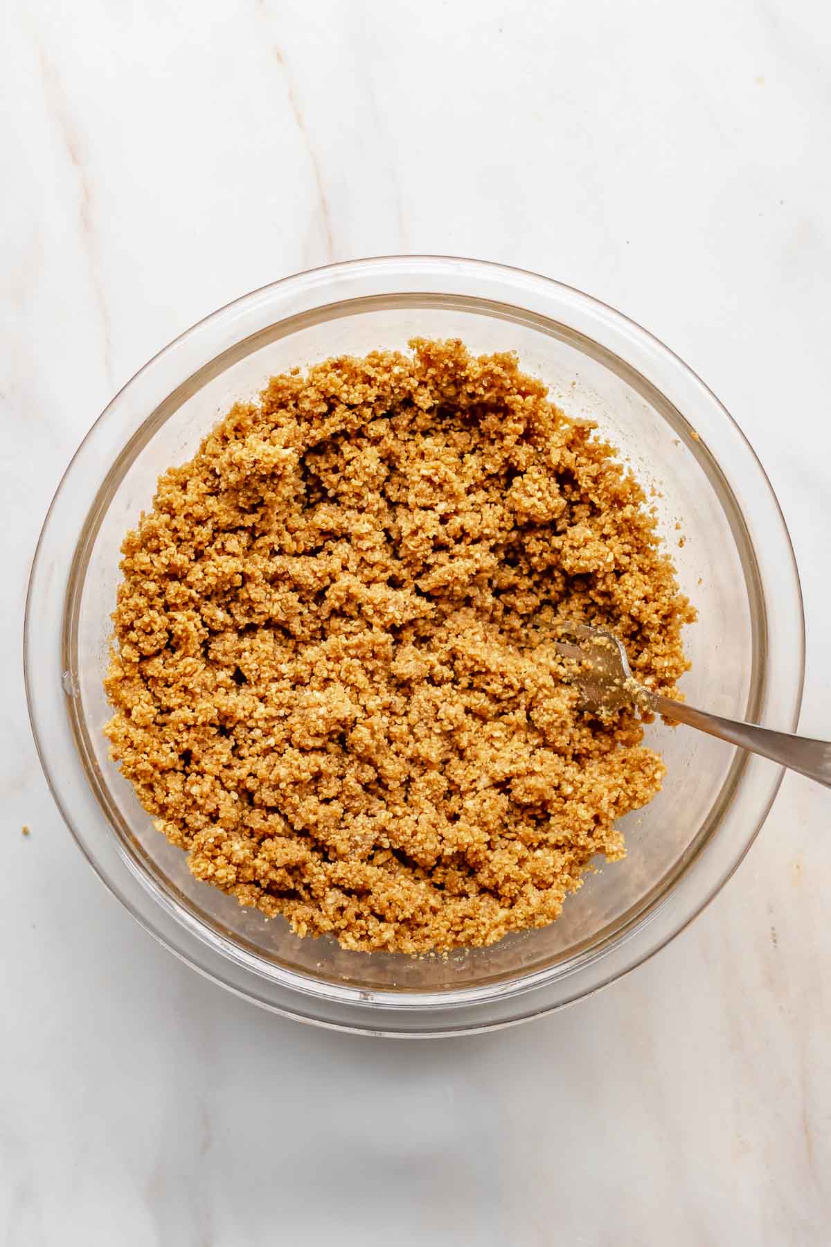 Graham cracker crust in a bowl with a fork.