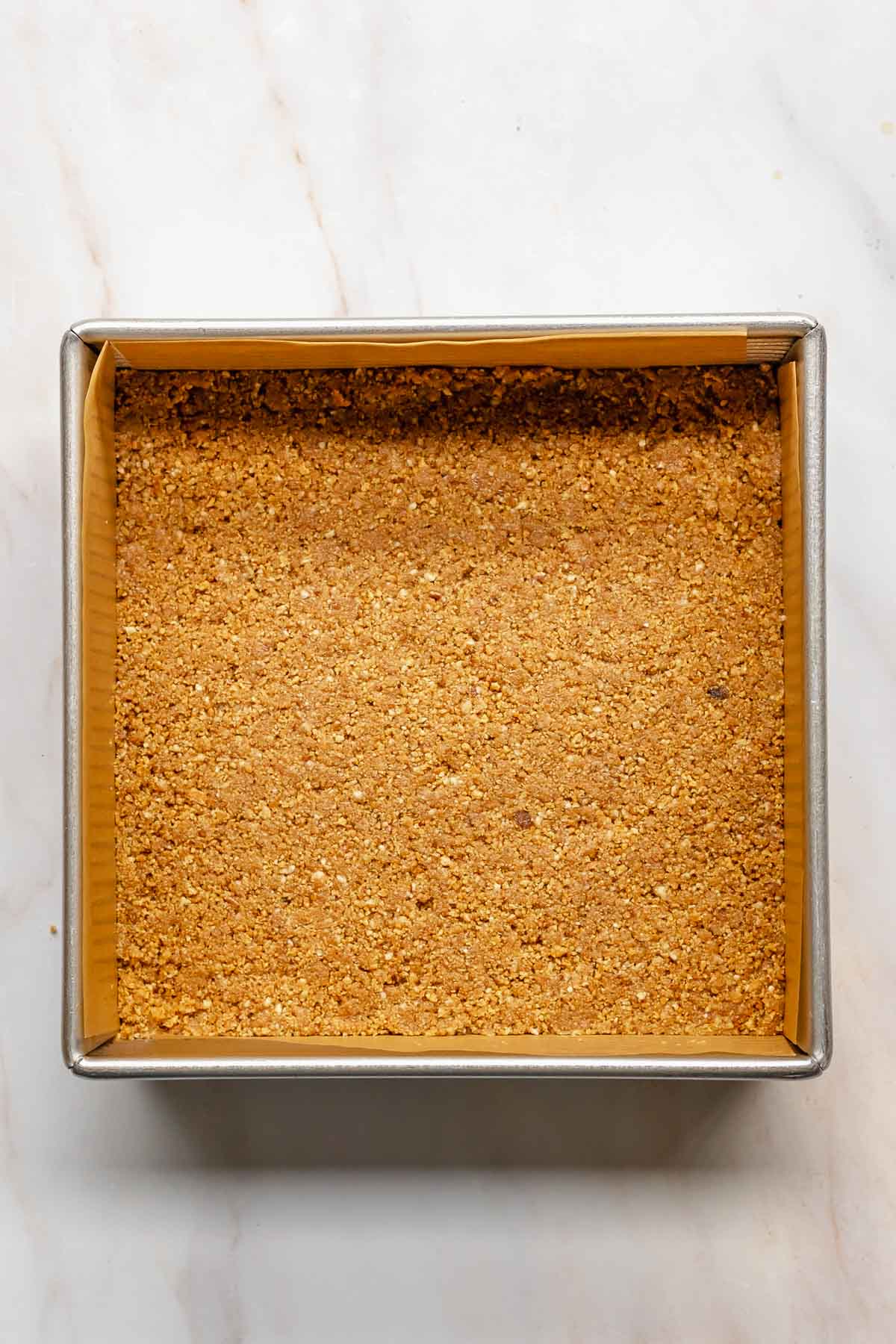 Graham cracker crust pressed into a square pan.